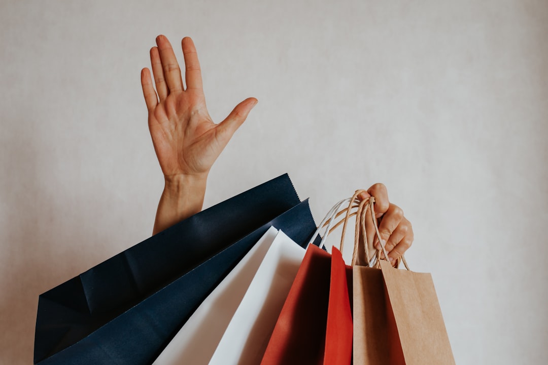 Happy woman holding in hand shopping package. Paper bag. Sale in store. Beautiful young girl in fashion shop. Customer buy present. Black friday sale. Holiday special offer, discount. Female in market — Foto: Iuliia Pilipeichenko / Unsplash