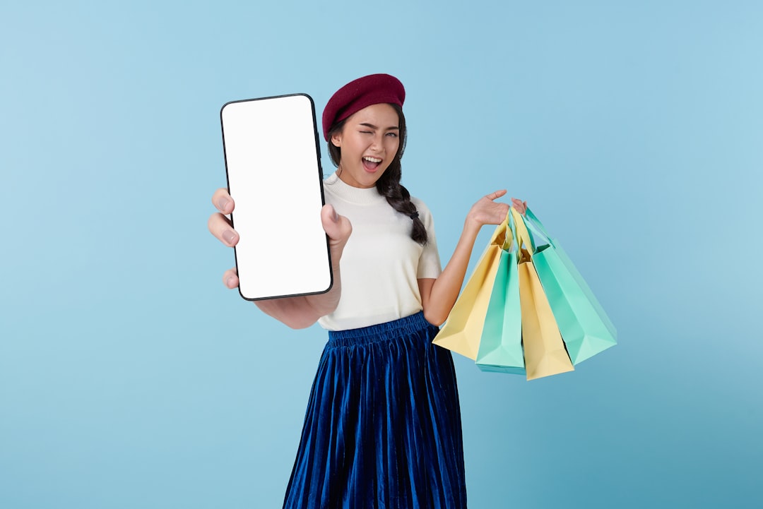 A woman holding a tablet computer and shopping bags — Foto: Rifki Kurniawan / Unsplash